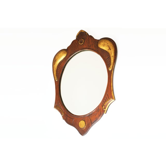 A stunning oval carved and giltwood mirror set within a carved wooden frame, made in Eastern Europe around 1900. The...