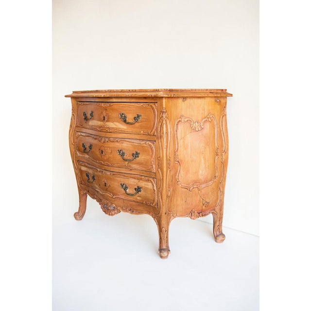 A 19th-century French Provincial three-drawer commode in the Louis XV Rococo style, crafted from solid European oak. The...