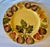 Hand crafted and hand painted serving platter featuring a pattern of pomegranates, strawberries, pears and leaves on a...