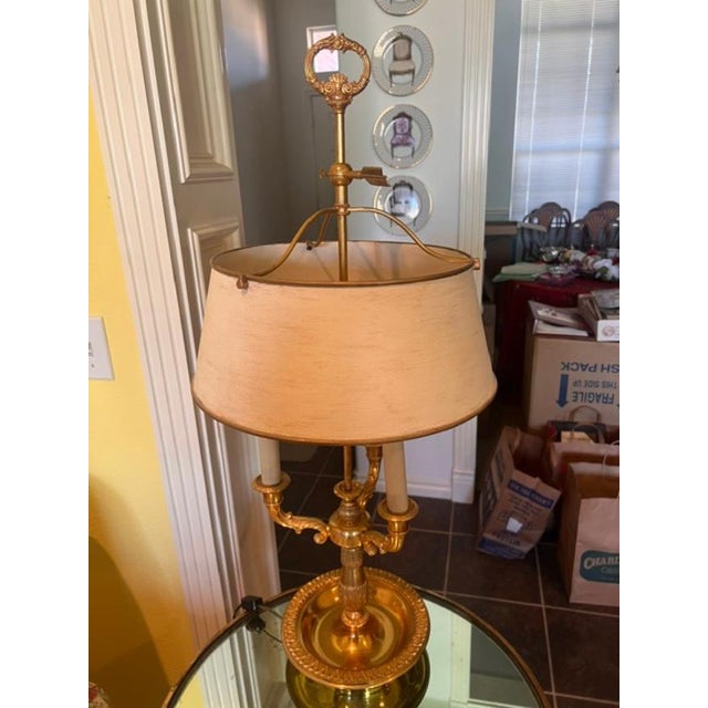 This elegant French Empire-style bouillotte lamp features a classic multi-candle brass design topped with a traditional...