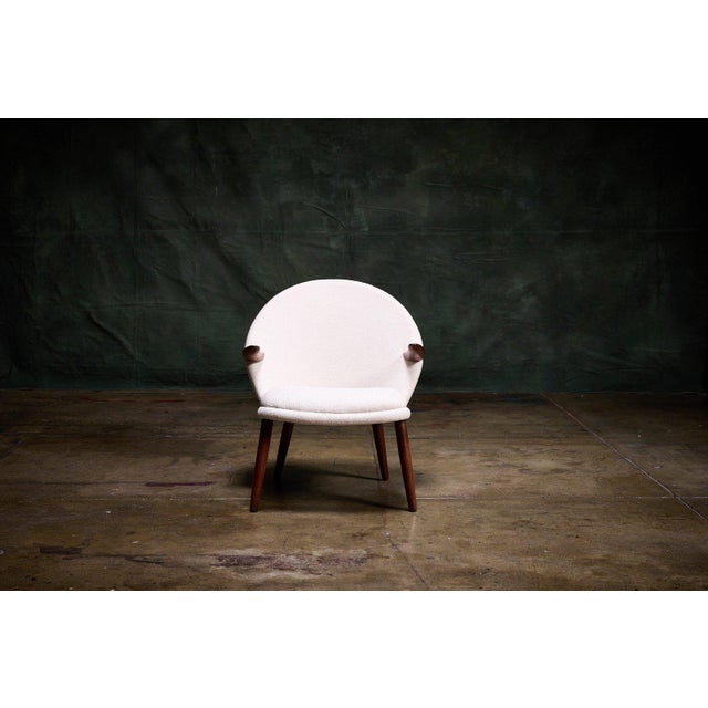 The Penguin Chair by Kurt Olsen is a mid-century Danish modern lounge chair with a rounded shell back and distinctive teak...