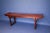 Asian-style wooden altar table with a long, narrow profile & warm finish.