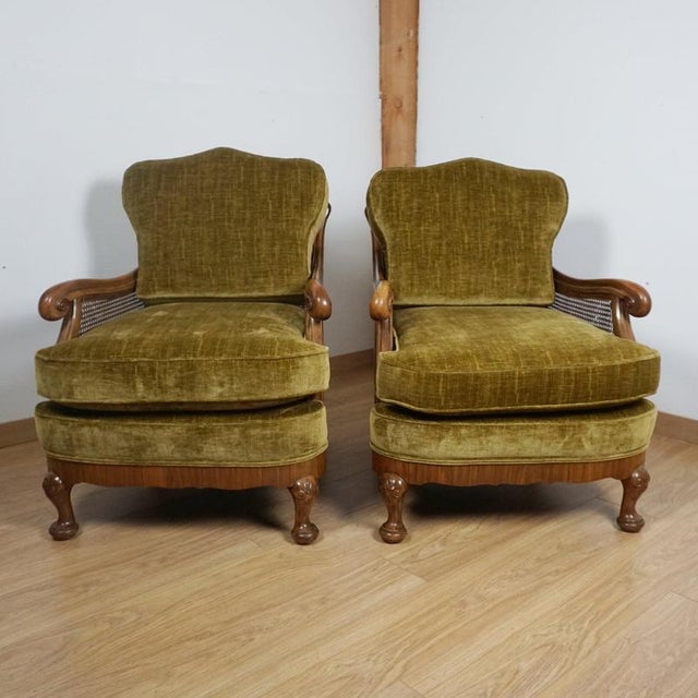 A pair of early 20th century bergère lounge chairs; solid and burr walnut throughout with original bergère cane work in...