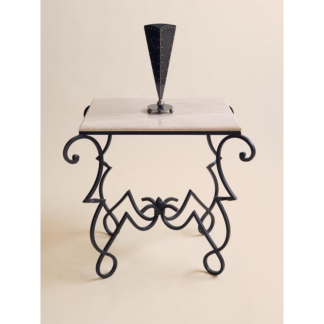 This vintage console table features a substantial stone top paired with an ornate wrought iron base in the French Art Deco...