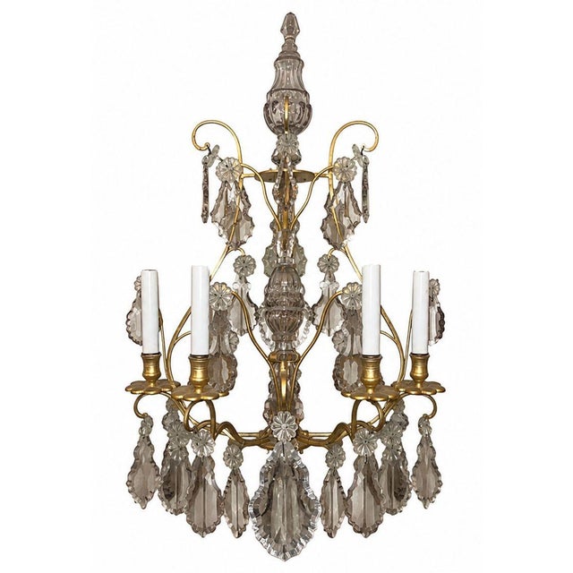 An elegant pair of French gilt bronze and crystal wall sconces dating to the late 19th century. Richly adorned with both...