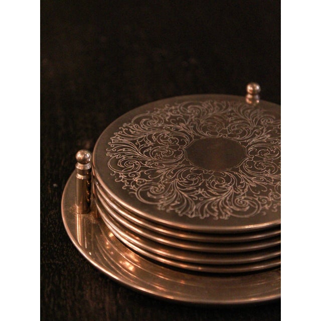 Set of six alpaca coasters with an arabesque pattern on a chromed metal surface. Decorative and functional, they include a...