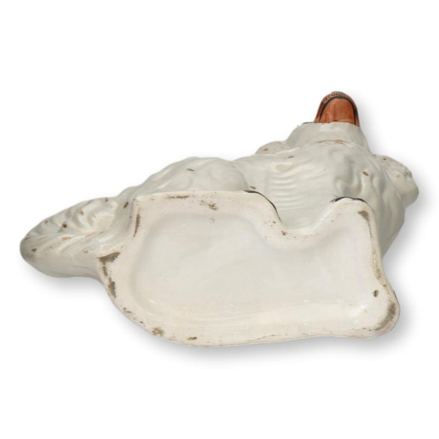 Pair of late 19th century English Staffordshire spaniel figures in the classic seated form, decorated in creamy white...