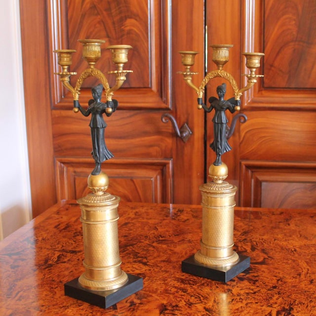 Each consisting of a gilt column form plinth with the Greek goddess Psyche perched on top of a globe. The butterfly winged...