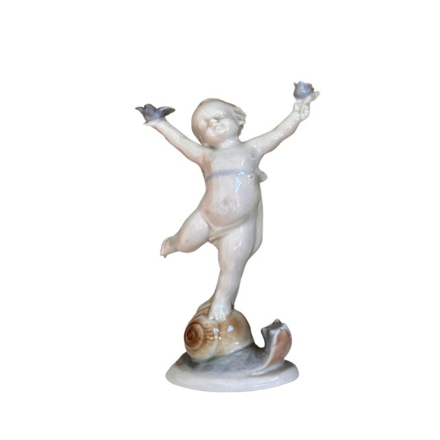A charming and beautifully detailed set of four vintage porcelain cherub figurines, each capturing a different playful...