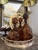A striking set of three tortoise glass decanters in rich amber and brown tones, each finished with an oversized round...