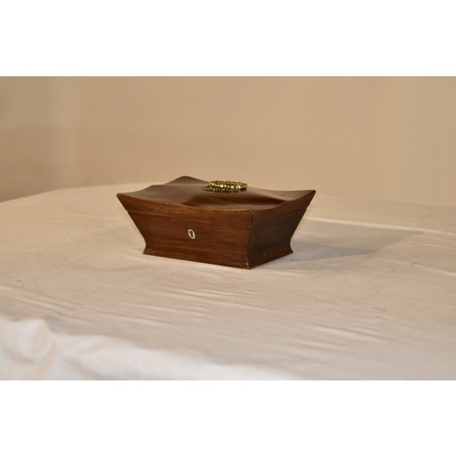 Period Georgian dresser box made from Rosewood. The lid is gracefully shaped and has a hand cast brass handle on the top....