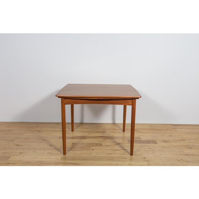 This square, extendable teak table was manufactured in Denmark in the 1960s. Its light, refined form lends it a light...