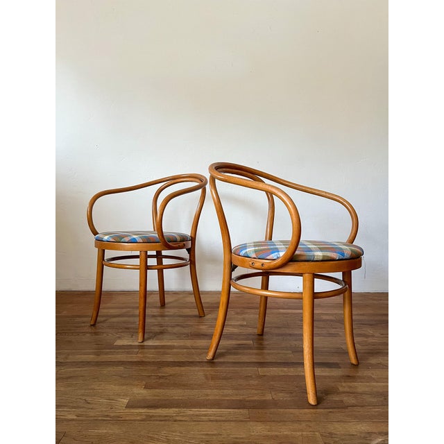A set of four original Thonet bentwood dining chairs, circa mid-20th century, featuring the iconic curved beechwood frames...