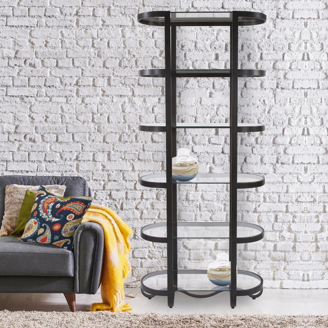The Brooklyn Etagere features a towering iron frame in a graphite finish with subtle gold accents and clear glass...