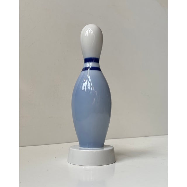 A rare ornament of a bowling pin. Executed in glazed white porcelain with blue accents/stripes. Dessin number 6132 by Bing...