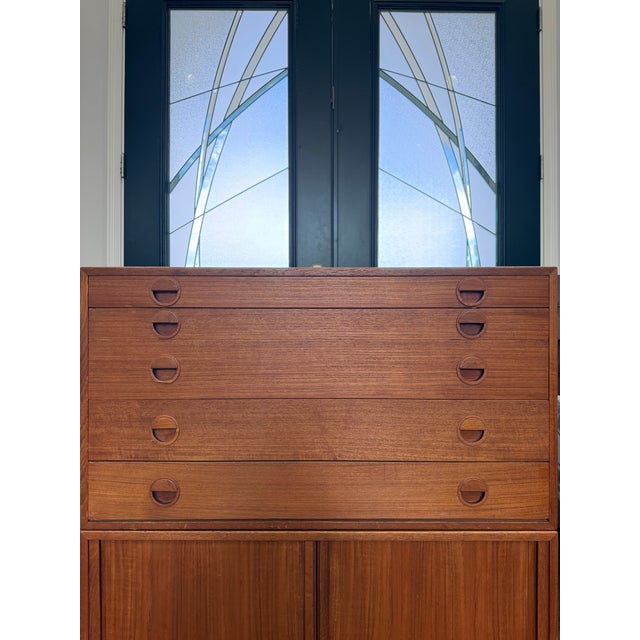 Authentic Danish modern modular wall unit cabinet set (2) featuring rich teak veneers, sculptural recessed pulls, and...