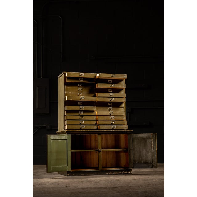 Green industrial sorting cabinet with 24 document drawers and sorting surface; also present is a large cabinet beneath....