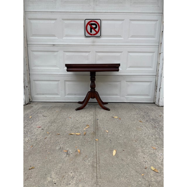 We have an absolutely stunning vintage Duncan Phyfe style mahogany pedestal table for sale. It features a rich mahogany...