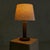 A French table lamp from the 1950s, attributed to Charles Dudouyt. The turned wooden base rises in a rhythm of stacked...