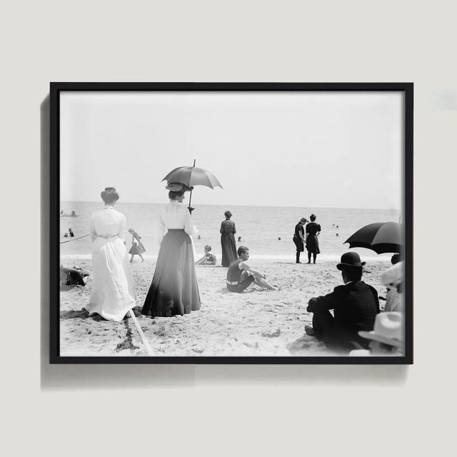 This vintage beach photo shows an assortment of early 20th century beach goers in various forms of dress in Palm Beach,...