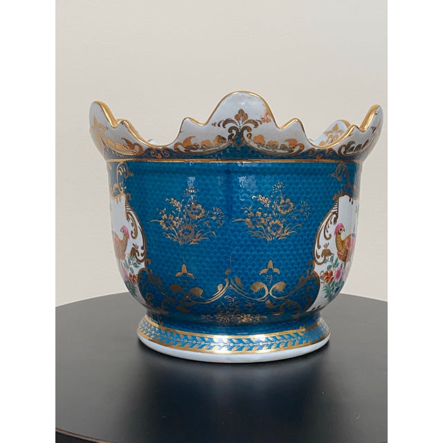 Vintage 1980s Chinoiserie porcelain cachepot featuring hand-painted peacocks and floral motifs against a richly glazed...