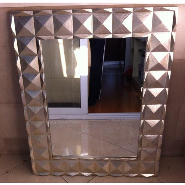 This striking Italian mirror with a bold geometric faceted carved frame in solid wood and finished with a silvered...