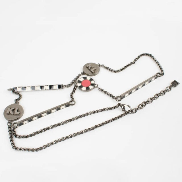 This elegant Karl Lagerfeld Paris extra-long sautoir necklace features a heavy gunmetal chain complemented with enamel...