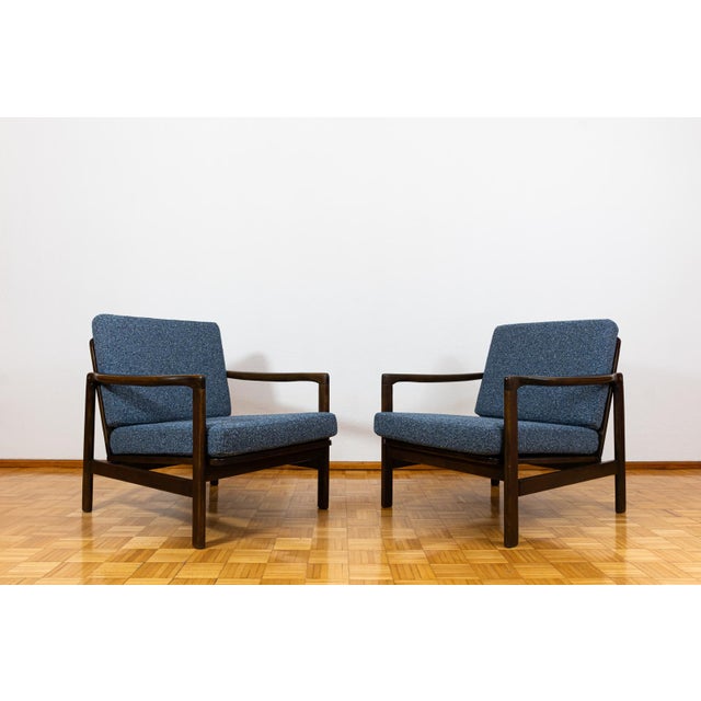 A pair of club chairs "type b7522," designed by zenon bączyk and produced in poland in the 1960s, exemplifies the...