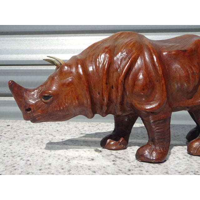 A stunning decorative piece depicting an Asian rhinoceros. This handcrafted item is distinguished by its meticulous...