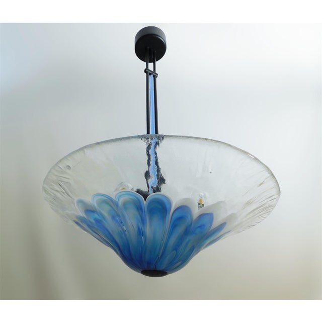Vintage Italian pendant with a Murano glass shade hand blown in clear blue and milky white colors, mounted on black metal...
