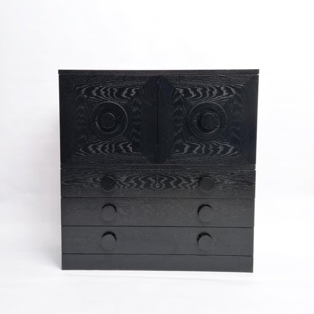 This striking Brutalist bar cabinet is crafted from black lacquered oak and was produced in Belgium during the 1970s....