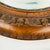 Beautiful antique round oak mirror featuring a compound serpentine profile embellished with hand carved details. An...