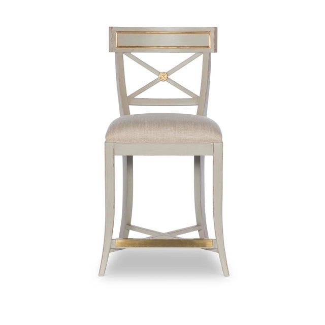 The Audrey counter stool is a delicately scaled stool that features soft grey paint with subtle hints ofgold leaf to...