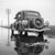 The photographer's note regarding this work is "with the Ford V8 on a wet street, Germany 1930s." This work comes to you...