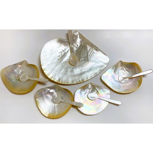 This is a set of gold-lipped mother of pearl dishes and spoons used for serving and consuming caviar. Presumably this type...