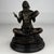 A striking 20th-century bronze sculpture depicting a seated Native American drummer, finely modelled in a serene cross-...