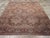 This early 20th-century Persian Isfahan room-size carpet presents a richly layered floral composition in muted rose, soft...