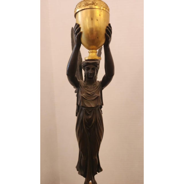 A pair of Empire style gilt bronze light candelabras, which have been patinated. Gold-finish bronze, gilt bronze, also...
