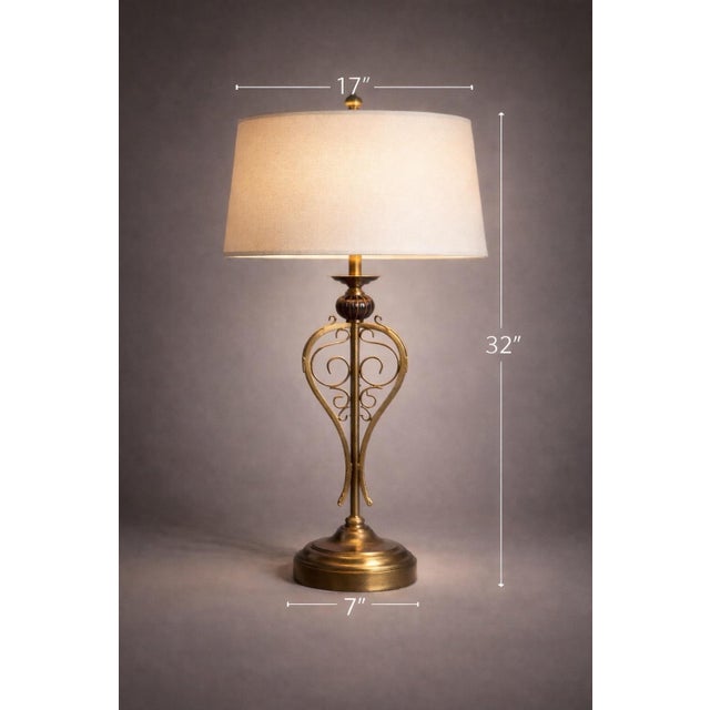 Graceful and architectural, this vintage table lamp features an elongated scrollwork form finished in a refined sunlit...