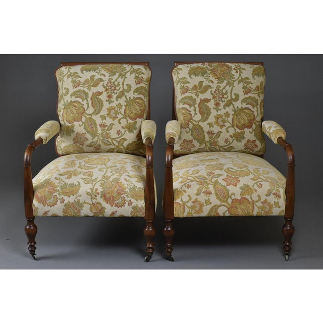 A refined pair of British lounge chairs, dating from the late Victorian to early Edwardian period (circa 1890–1910). These...