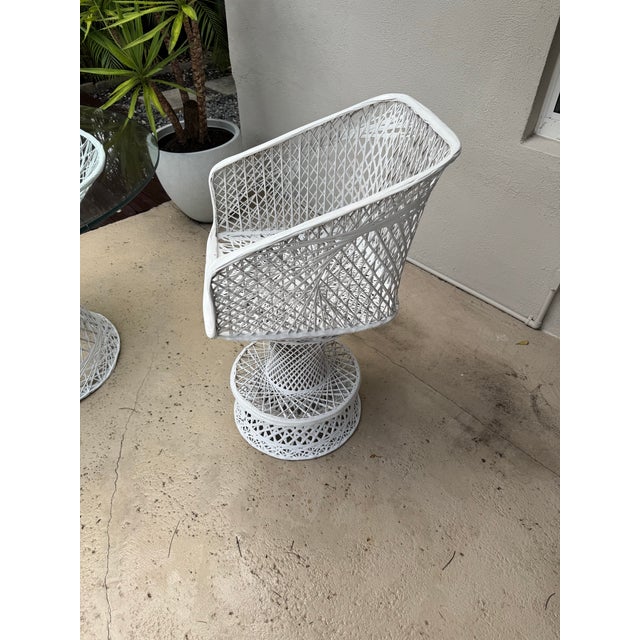 Features a distinctive white webbed design chair and a round glass-top table. Designer: Attributed to Mid-Century designer...