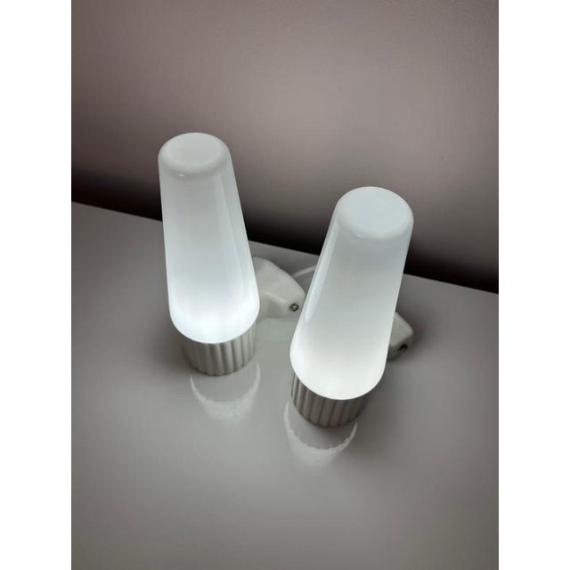 This set of two wall lamps, model 6020, is a design by Swedish designer Sigvard Bernadotte for the renowned manufacturer...