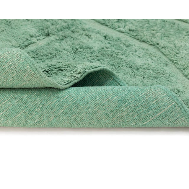 A forest canopy distilled into a single, luxurious hue. This hand-knotted wool rug builds its quiet richness from tone...