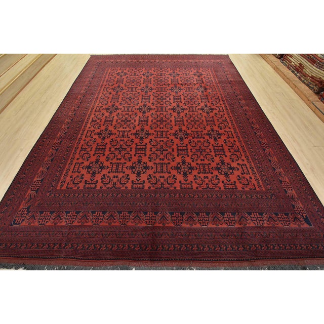 A traditional Turkmen rug hand-knotted with fine wool and natural dyes. This rug features rows of geometric medallions...
