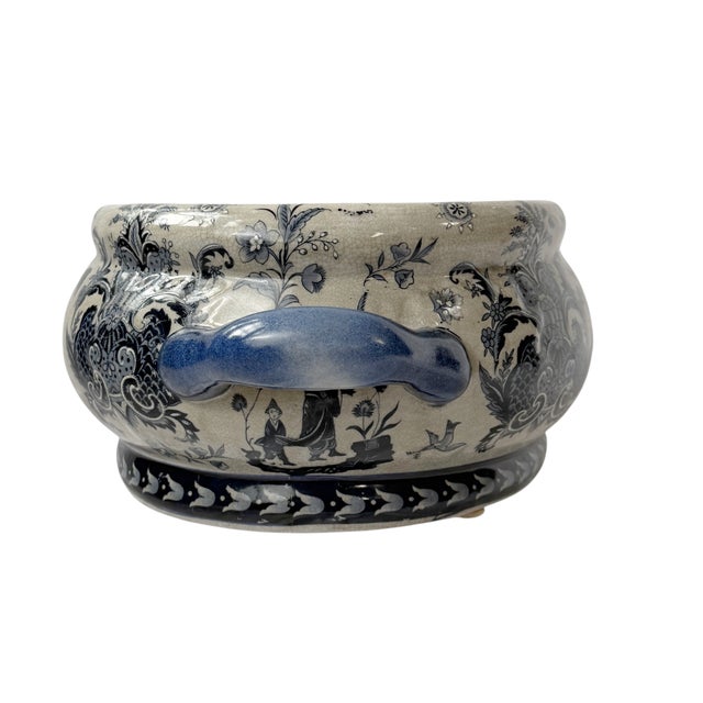 This is a late 20th century chinoiserie ceramic footbath featuring a deep indigo and cream palette. The oval body is...