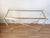 Rectangular design console in lucite and gold metal, glass top. The tubular base is connected by an X-shaped spacer. Good...