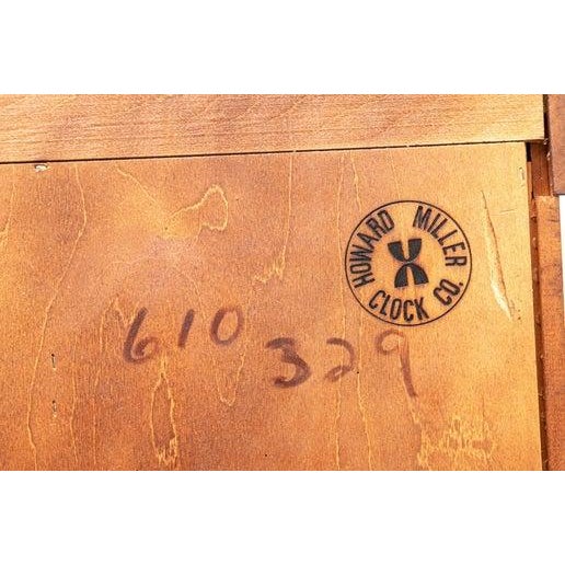 An impressive Howard Miller Solomon grandfather clock. Featuring a Cherry Bordeaux finish, swan-neck pediment, rare...