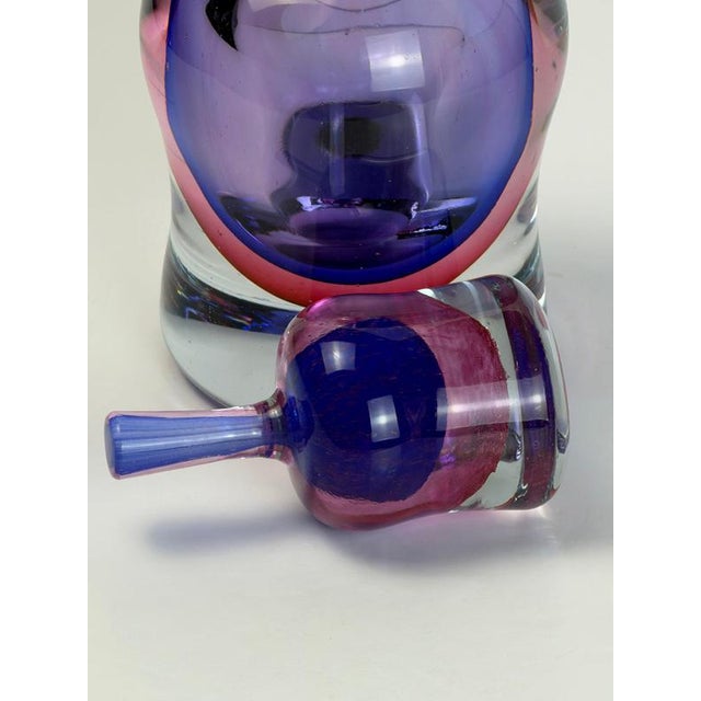 A substantial Murano glass decanter from the 1980s, attributed to Formia, with a compact bottle form and vivid purple and...