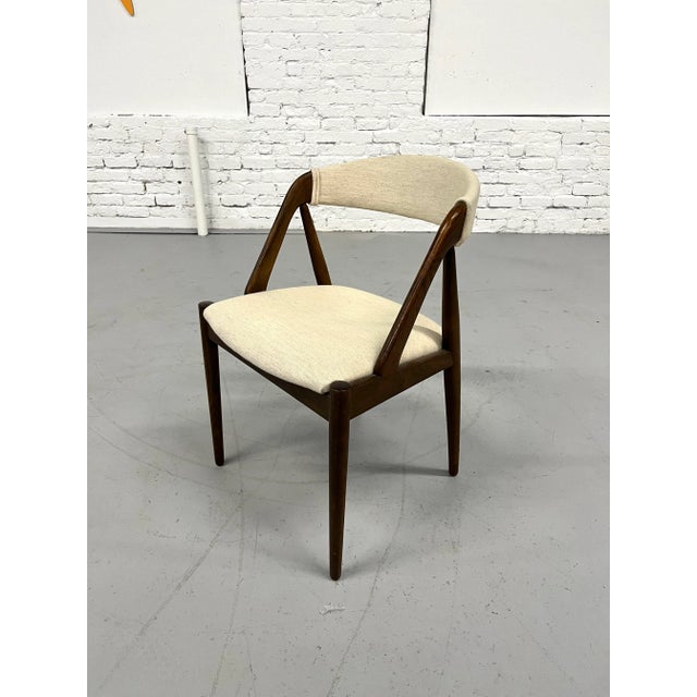 Clean Model 31 chair in walnut with a white wool upholstery. About the designer: Kai Kristiansen was born in 1929. He...