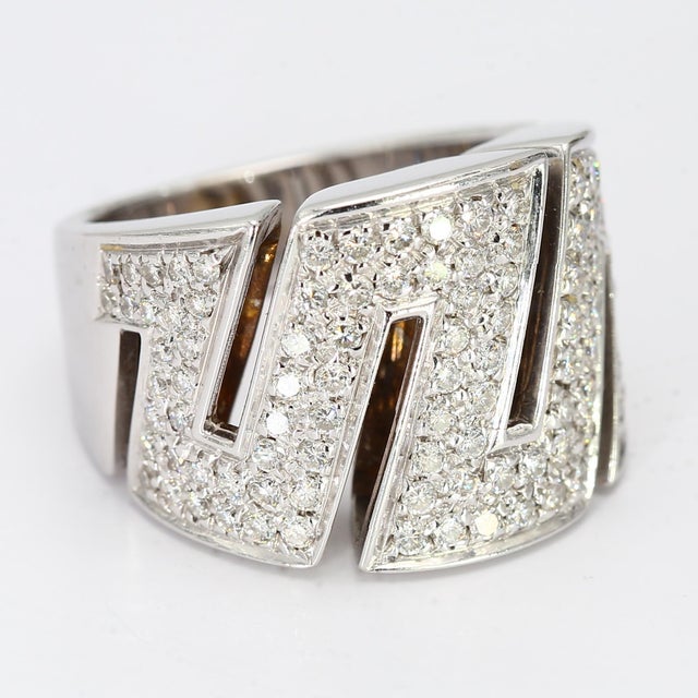 This is a large 18k white gold ring in an art deco style with a "Zig-Zag" design. The ring sports one hundred and fifteen...